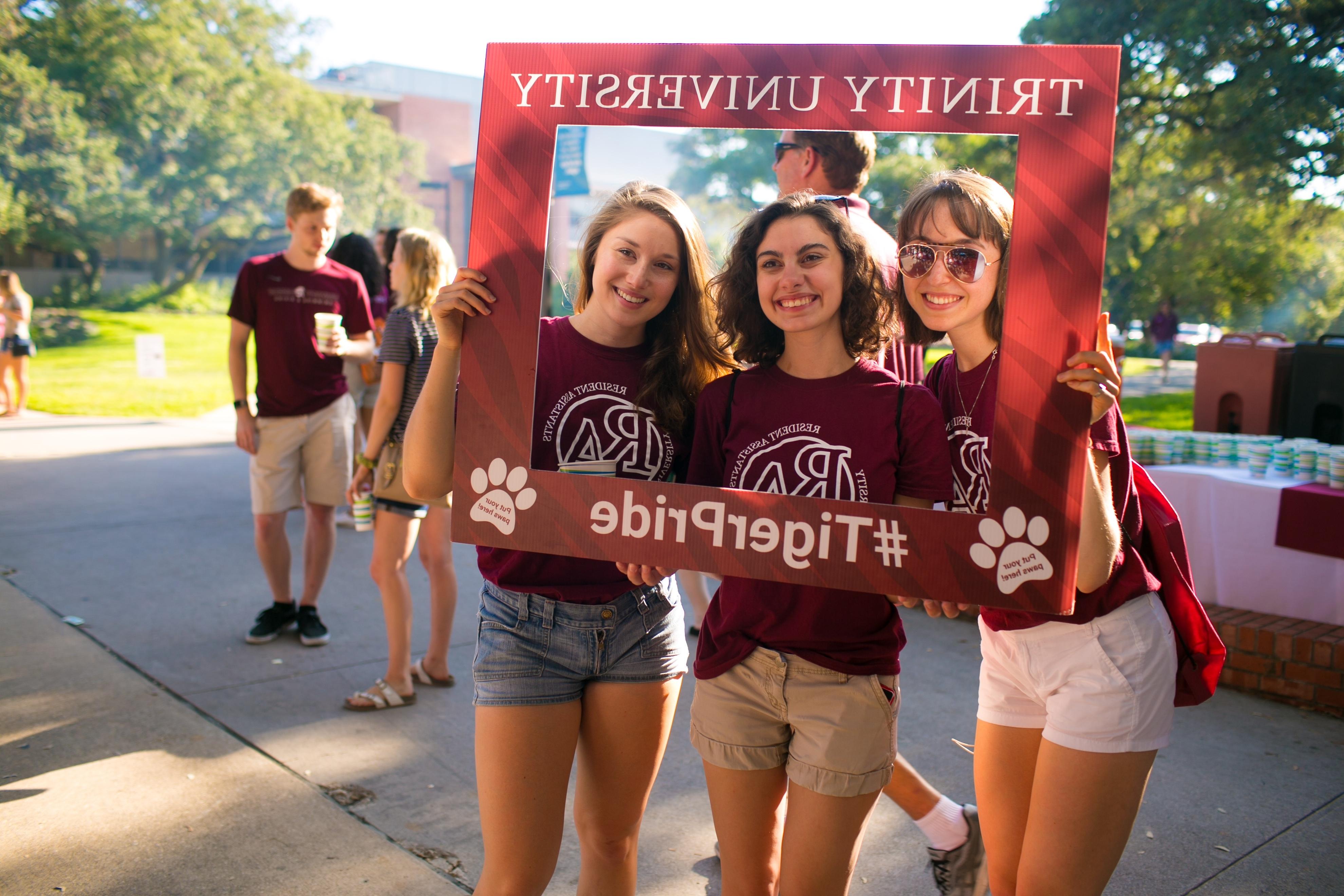 photo of students smiling and holding a TigerPride photo boarder